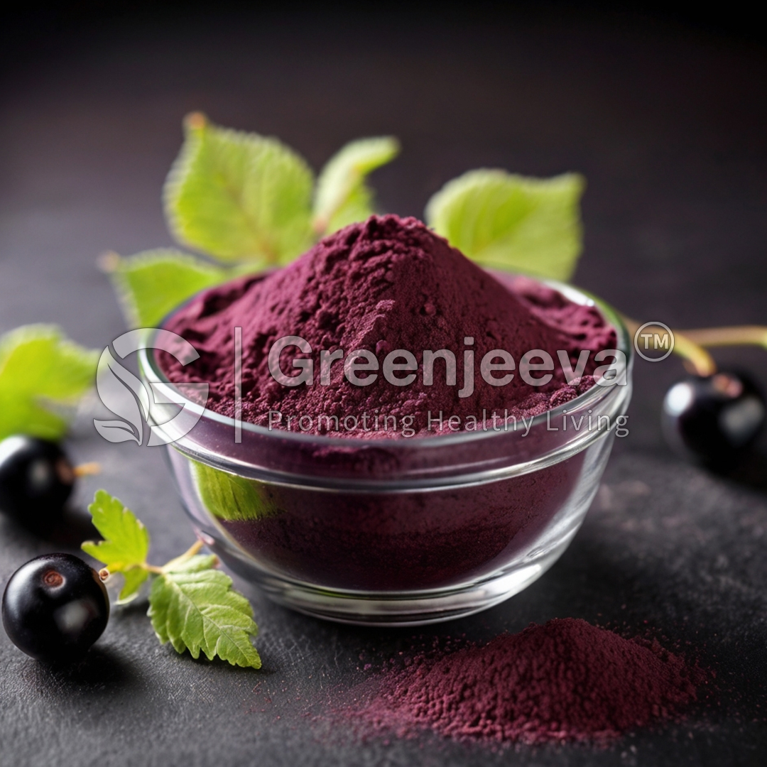 A glass bowl filled with Organic Black Currant Powder, surrounded by fresh green leaves and dark berries, on a dark background.