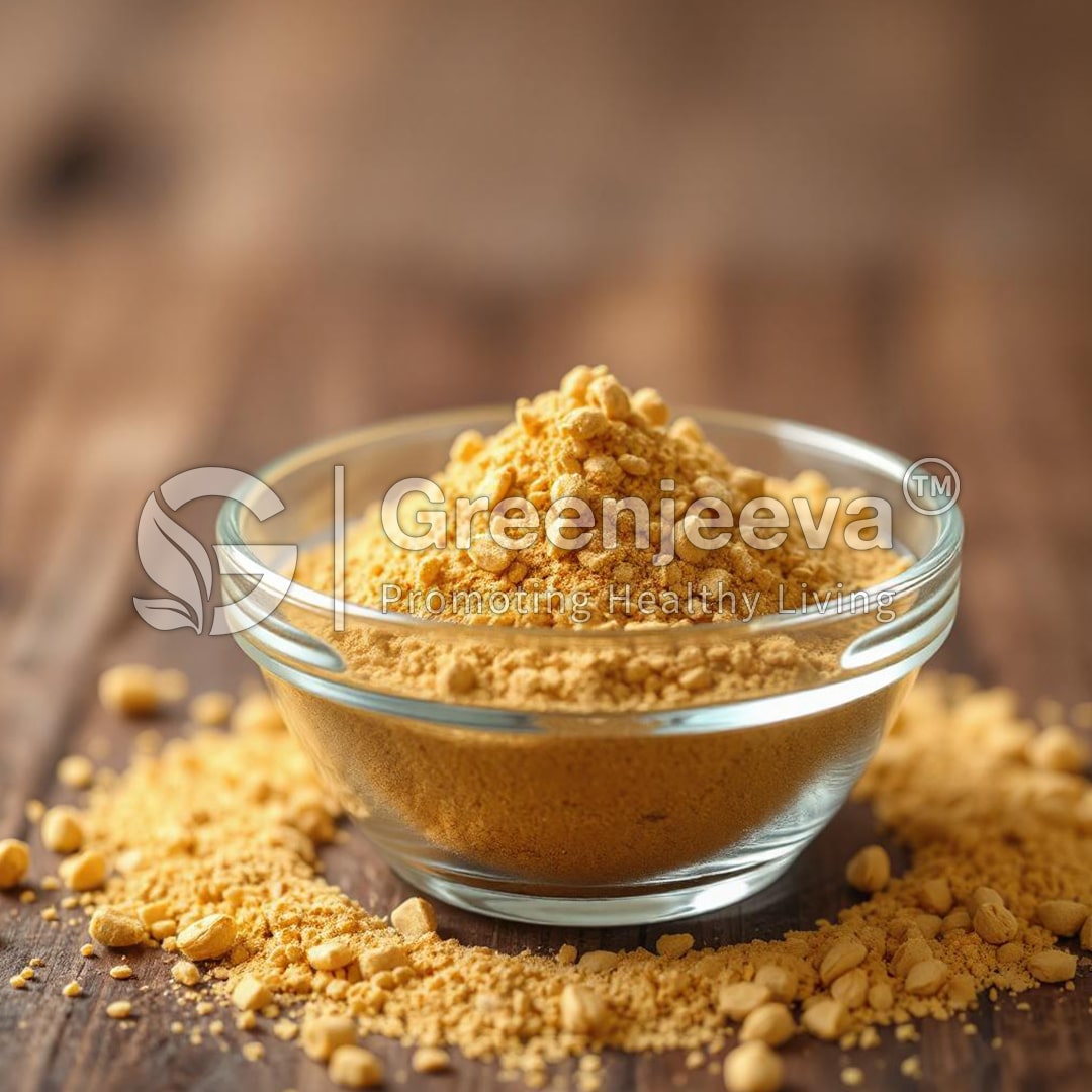 A glass bowl filled with Bee Pollen Powder, surrounded by scattered granules, set against a rustic wooden background.