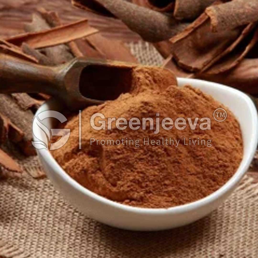 A small white bowl filled with brown spice powder, surrounded by cinnamon sticks on a textured surface.