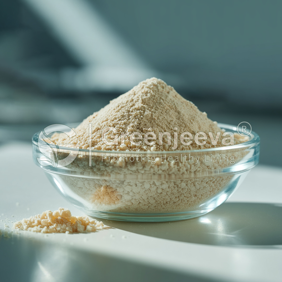 A glass bowl filled with a fine, off-white powder, with some powder spilled onto the surface beside it. Natural and healthy focus.