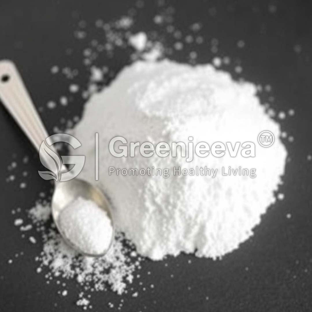 A mound of Betaine Powder Hcl Salt sits on a dark surface with a silver spoon partially filled beside it.