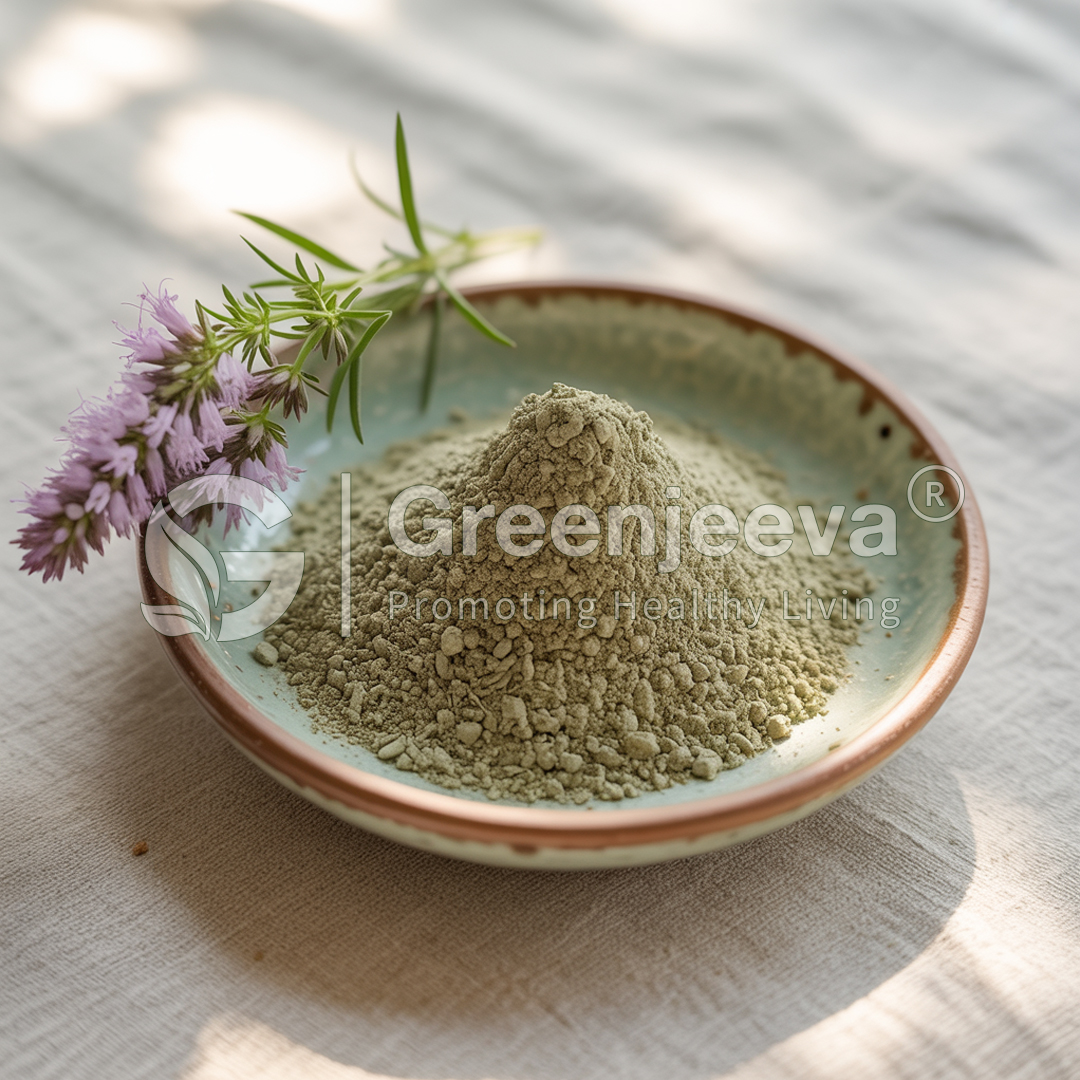 A small mound of Hyssop Herb powder in a ceramic bowl, accompanied by a sprig of lavender flowers, on a light fabric background.