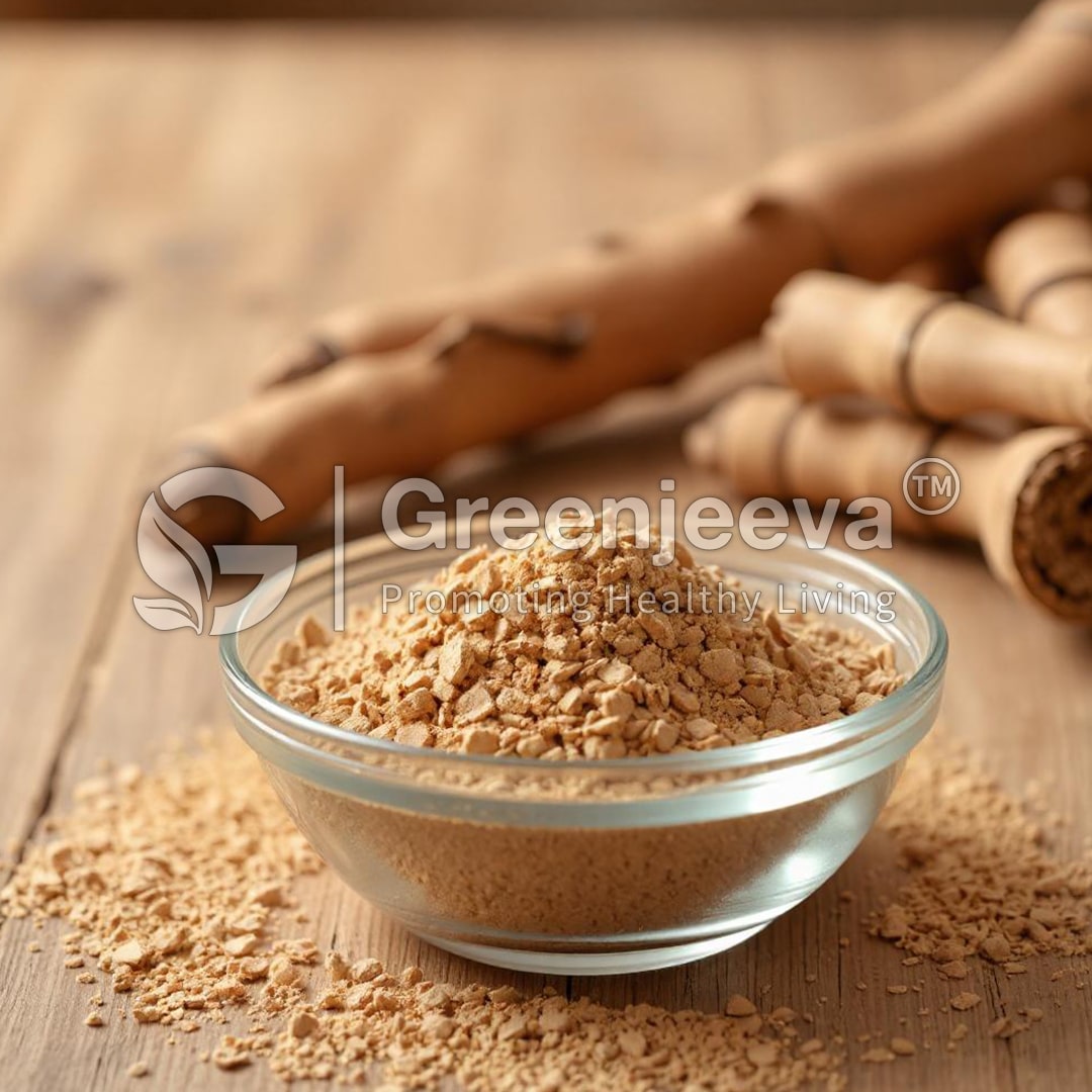 A glass bowl filled with fine, Liquorice Powder, surrounded by pieces of cinnamon sticks on a wooden surface.