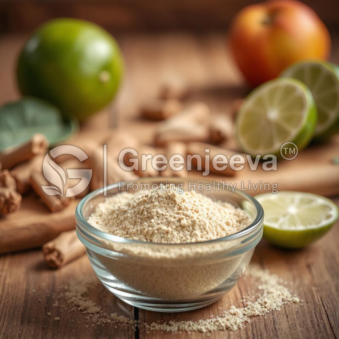 A glass bowl filled with Organic Lime Fruit Powder sits on a wooden surface, surrounded by fresh limes, an apple, and cinnamon sticks.
