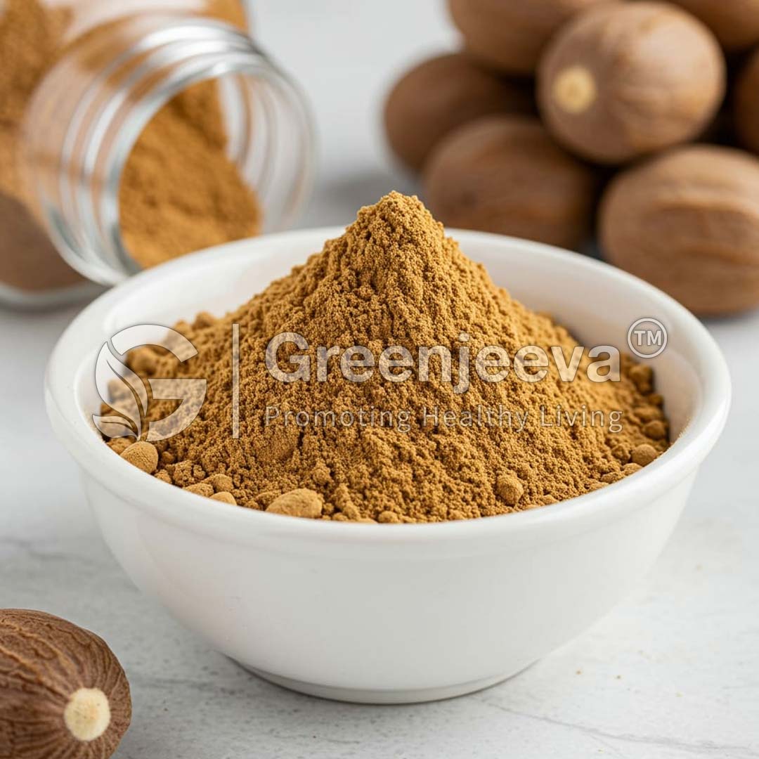 A close-up of a white bowl filled with finely ground Organic Nutmeg, Whole, surrounded by whole nutmeg fruits and a jar of spice.