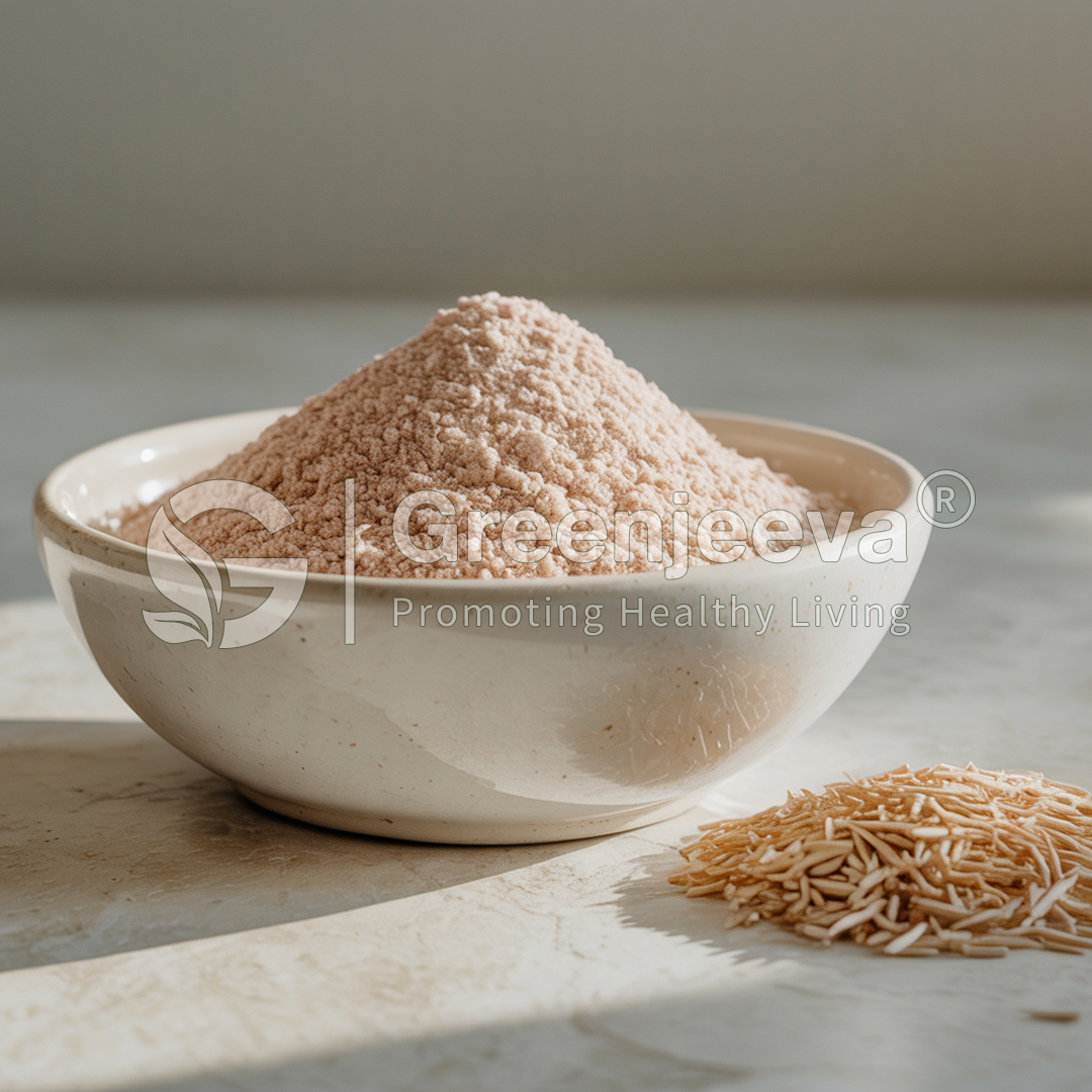 A bowl of fine pink powder sits on a marble surface, with small, thin noodles beside it, illuminated by soft natural light.